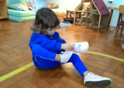 Maya colocando seu tênis sozinha.